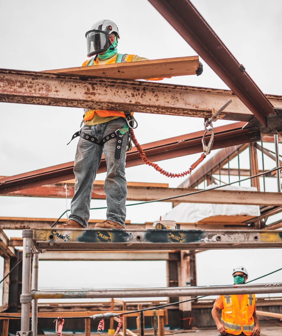 Photo of construction worker on steel beam